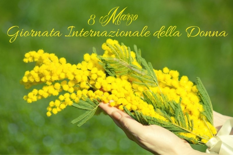 ramoscello di mimosa in mano donna 8 marzo giornata internazionale della donna