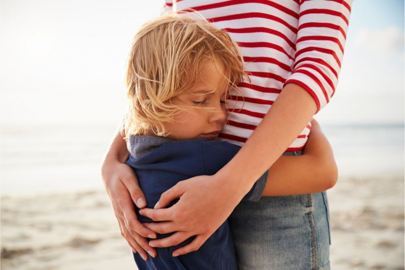 donna mamma jeans maglietta righe rosso bianco abbraccia figlio bambino capelli biondi