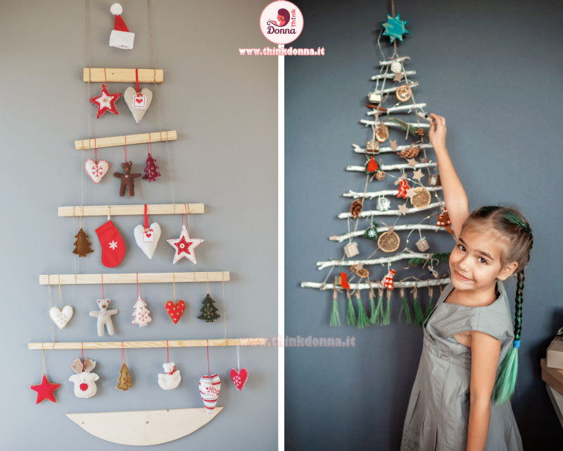 decorazione natalizia alternativa albero di Natale a muro fatto con assi di legno cuori anilami di stoffa rosso bianco cappello di babbo natale viso bella bambina decora rami secchi fette arancia essiccate stelle 