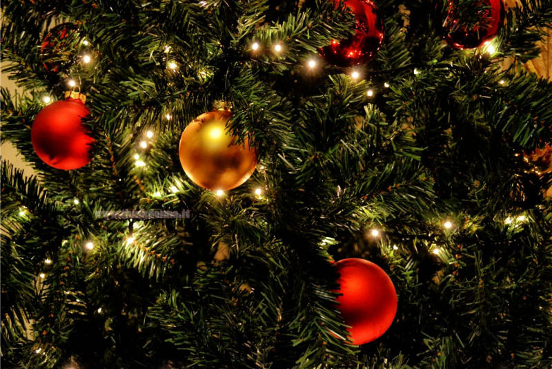 decorazioni natalizie palle rosso oro luci tra i rami Albero di Natale verde