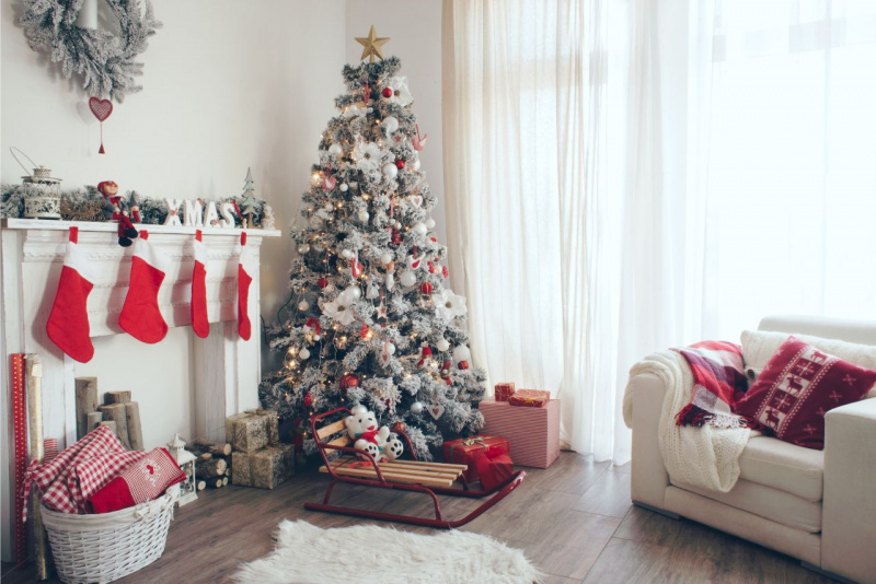 decorazioni natalizie rosso bianco slitta su parquet di legno cesta vimini bianca regali di Natale