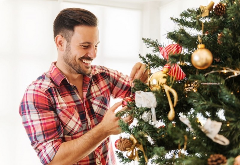 uomo decora albero di natale decorazioni vintage sorriso