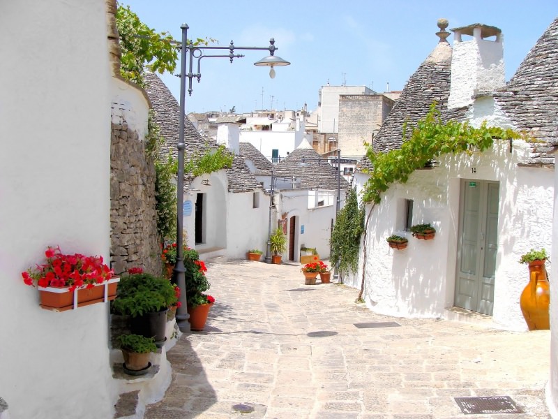 trulli di alberobello case con fiori gerani rossi