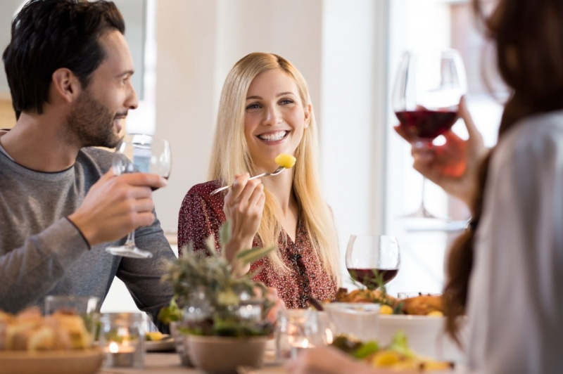 coppia uomo bello sorriso donna capelli biondi al ristorante con amici