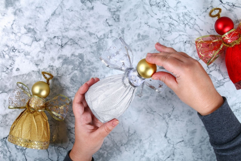 montaggio testa angelo pallina dorata lavoro manuale decorazione natalizia oro argento roso mani