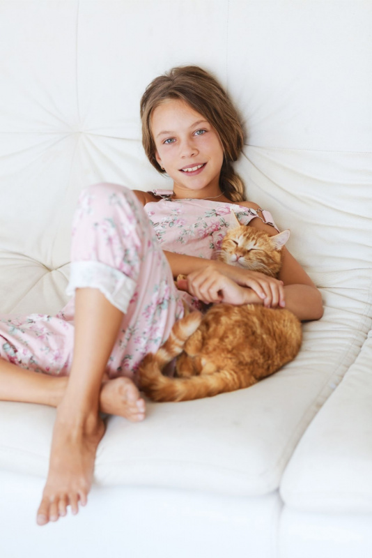ragazzina abbraccia animale domestico micio letto