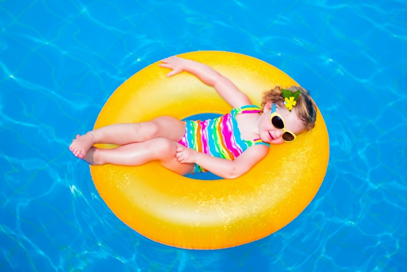 bambina in piscina galleggia ciamnella costume da bagno occhiale da sole protezione solare