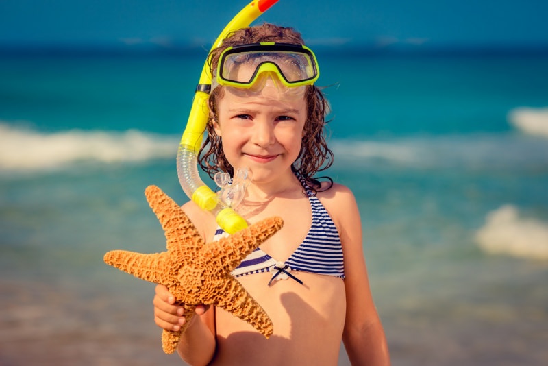 bambina al mare maschera costume estate protezione stella marina