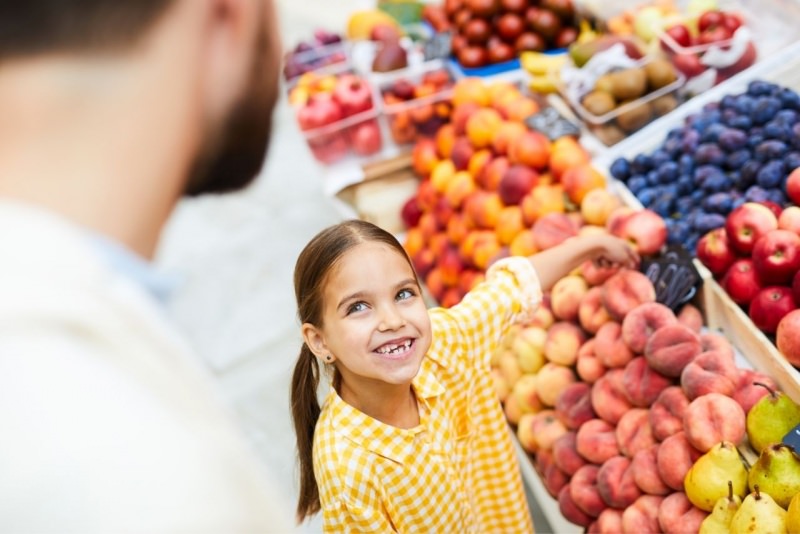 bambina sorridente con il pap sceglie frutta fresca reparto 