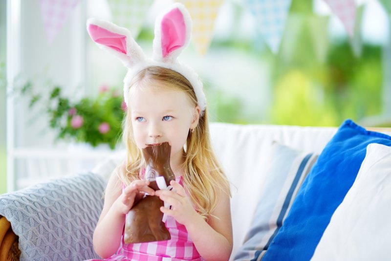 bambina mangia coniglietto cioccolato pasqua orecchie 