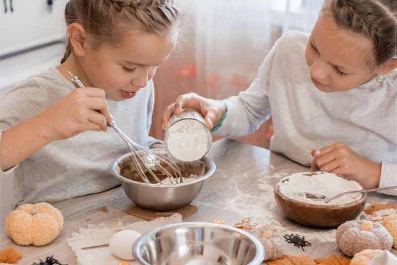 preparazione biscotti Halloween bambine capelli biondi treccia ragnetto ciotola zucca farina