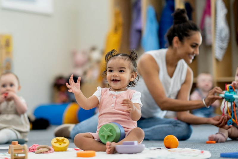 bambina sorridente gioca con giocattoli asilo nido