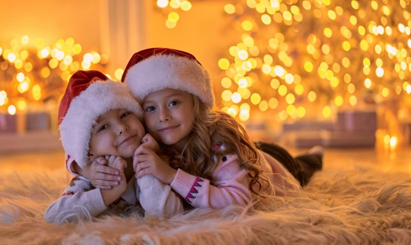 bambini aspettano il Natale luci cappello rosso bianco