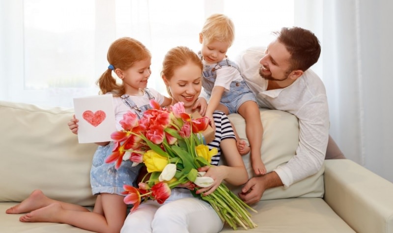 famiglia felice bambini figli e pap danno regalo mamma festa fiori 