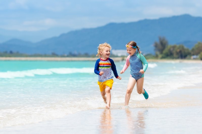 bambini giocano felici spiaggia sabbia mare cielo azzurro estate