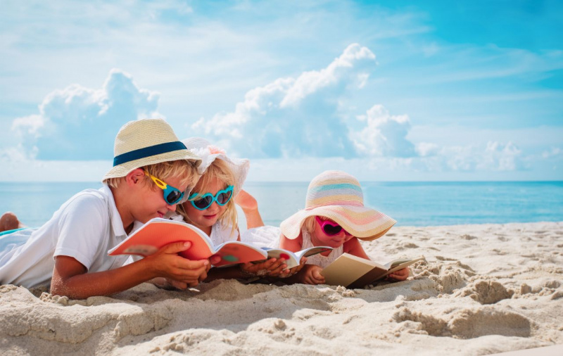 fratellini bambino bambine sorella lettura spiaggia sabbia mare 