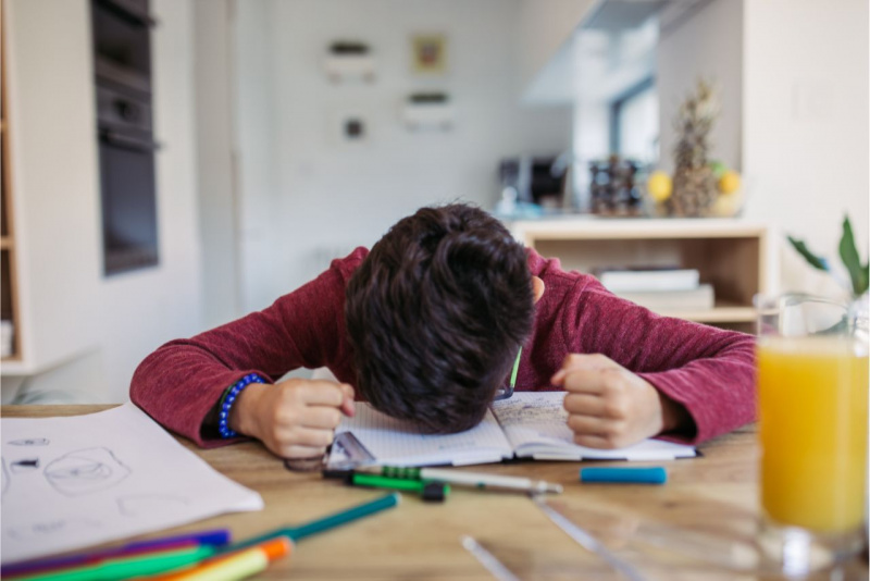 bambino poggia la testa suo quaderni compiti per le vacanze libri penne