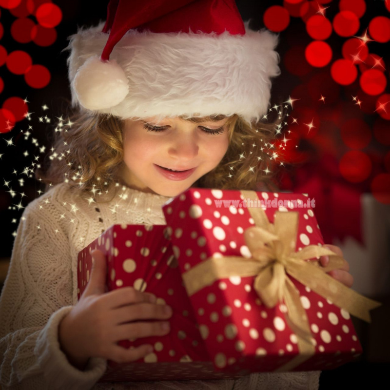 magia spirito del Natale bimba capelli biondi sorriso luccichii cappello Babbo Natale rosso bianco pelliccia sintetica