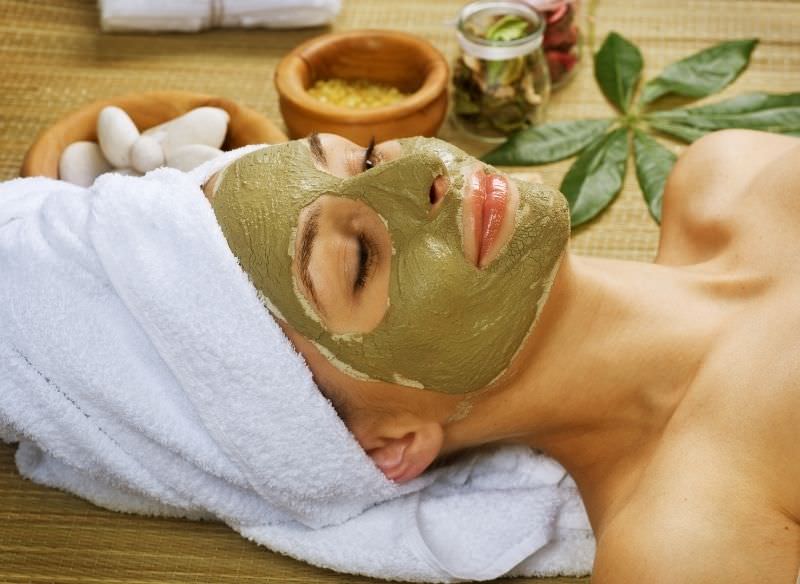 viso bella donna con maschera bellezza argilla verde relax SPA ciotola sassi telo spugna