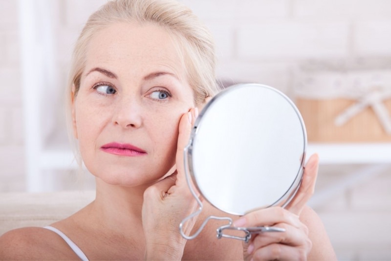 viso bella donna matura guarda rughe allo secchio rotondo