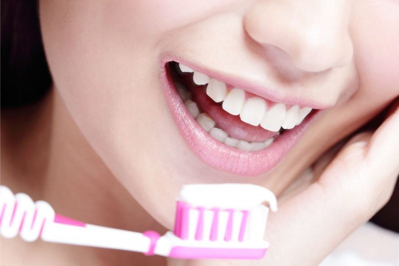 spazzolino rosa e bianco con dentifricio a pasta bianca sorriso denti bianchi
