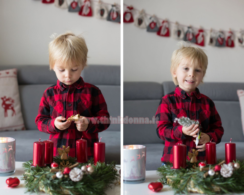 decorazioni natalizie preparare corona Avvento con candele rosse con bambino felice 