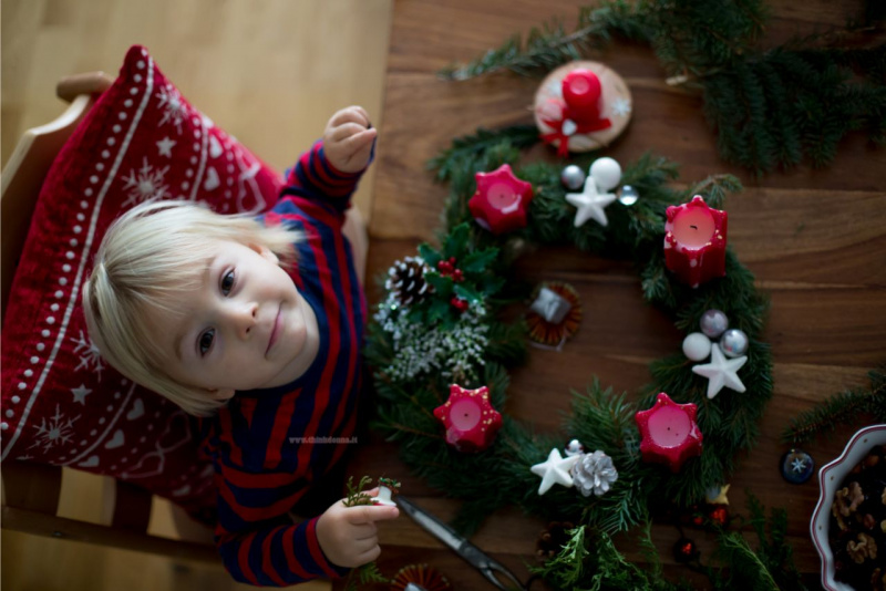 preparazione Avvento corona viso bel bambino decorazioni natalizie sedia cuscino rosso bianco