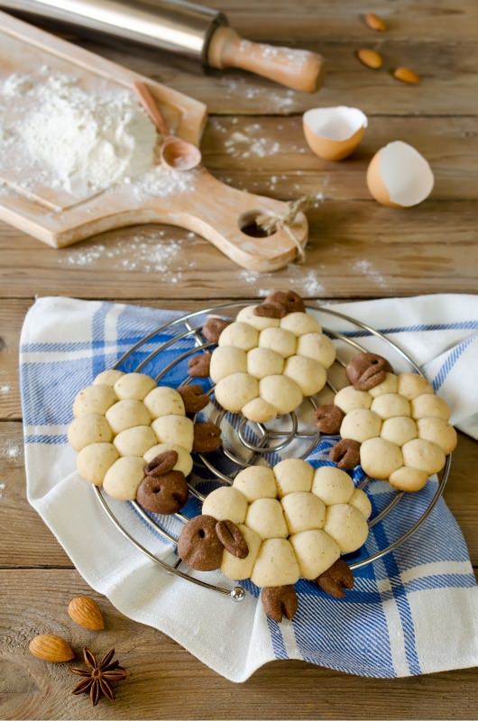 preparazione biscotti pasquali a forma di agnellini griglia tagliere zucchero a velo matterello mandorle