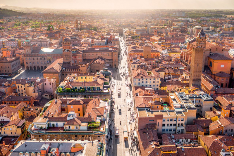 veduta aerea Bologna città vie principali case tetti rossi sole