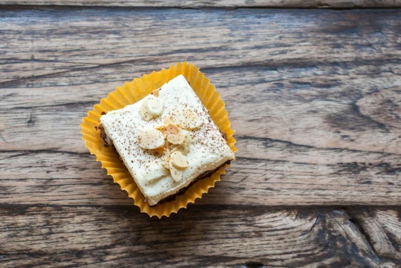 brownie glassato cioccolato bianco fette mandorle paino legno pirottino giallo