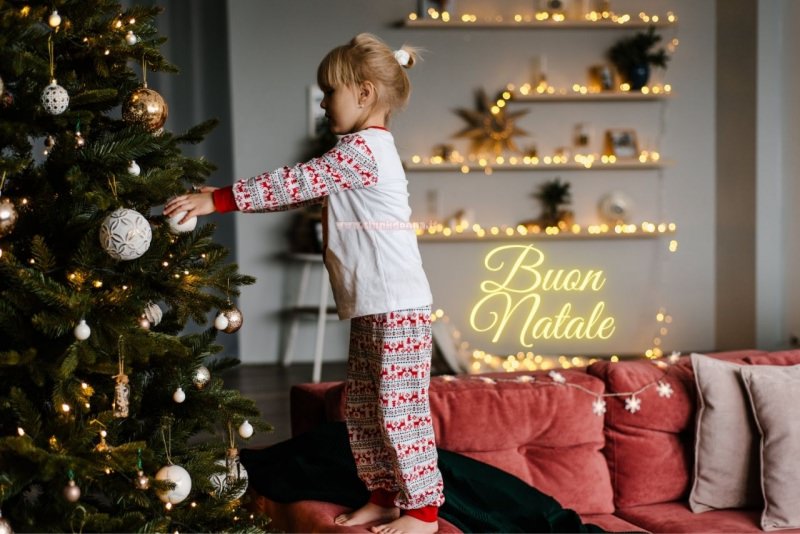 bambina decora albero di natale festa luci decorazioni natalizie oro divano palline