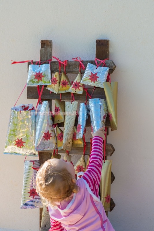 calendario dell'avvento pacchetti su scala legno bambino prende regalo