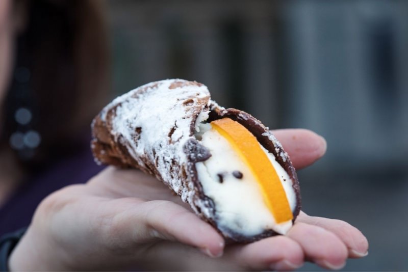 cannolo di ricotta siciliano sulla mano di donna