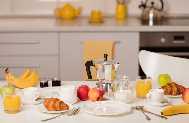 colazione italiana sana caff caffettiera moka croissant cornetti mela marmellata banane spremuta arancia tavola