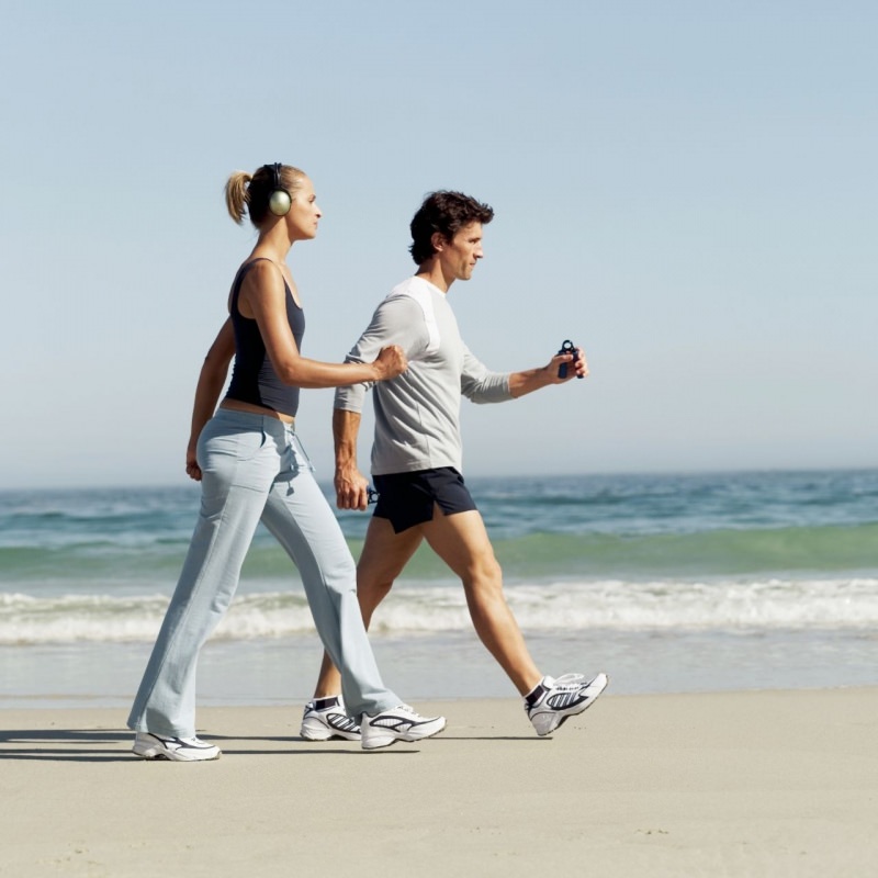 giovane coppia uomo donna camminano veloce passeggiata riva al mare