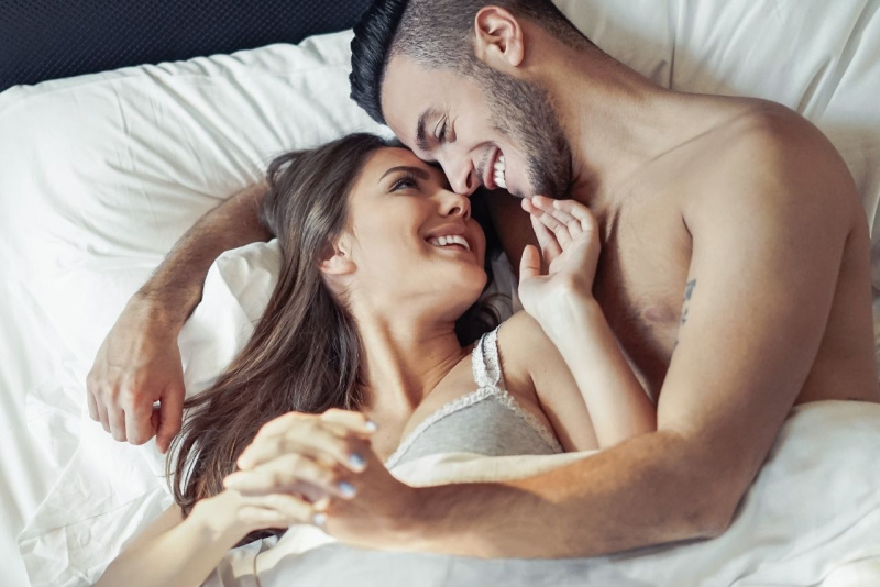 coppia romantica innamorati a letto sorrisi