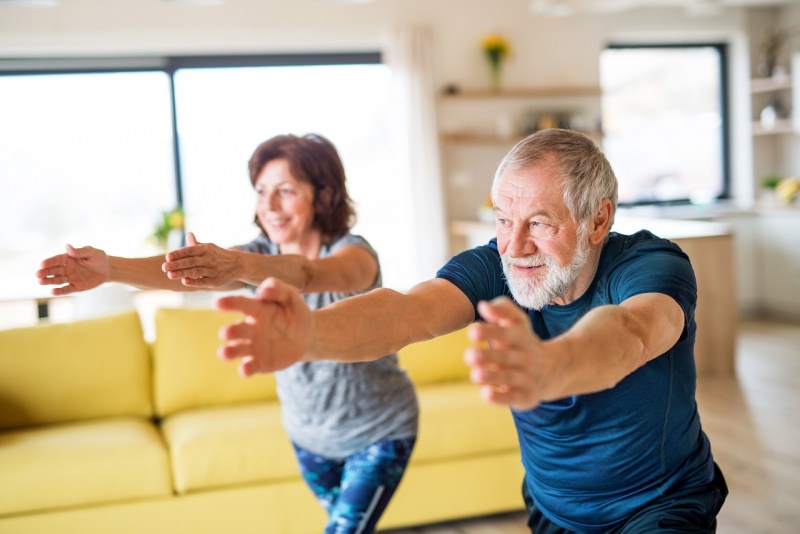 coppia uomo donna anziani fanno esercizi fisici fitness resto a casa