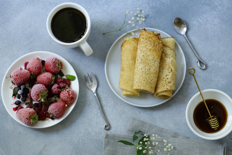 crpes arrotolate ciotola frutta fragole mirtilli zucchero tazzina caff spargi miele