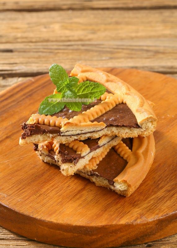 fette di crostata alla nutella su piano di legno foglie di menta dolce