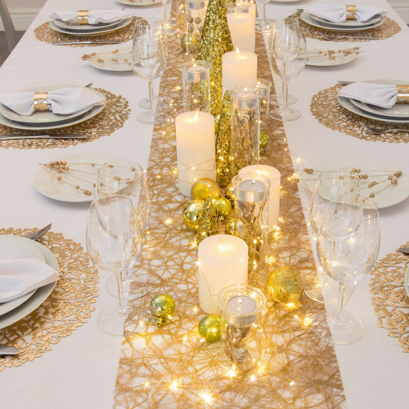 tavola apparecchiata a festa piatti porcellana bianca portatovagliolo anello oro runner sottopiatti dorati pizzo calici cristallo