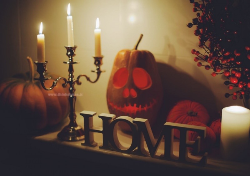 halloween decorazioni interni camino candelabro candele accese scritta home zucca