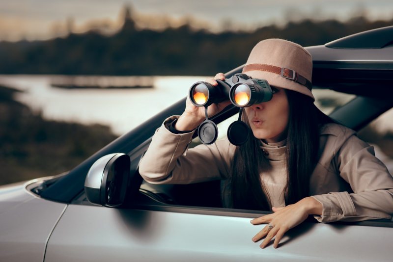 donna detective con binocolo auto investigazione privata