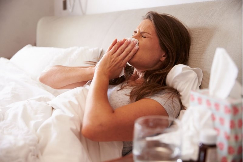donna a letto raffreddore influenza si soffia naso