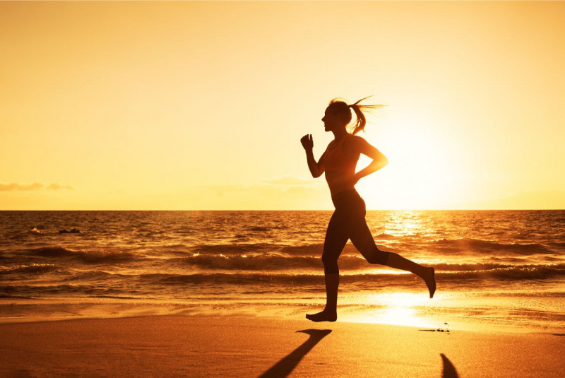 allenamento tramonto al mare donna fisico atletico corre
