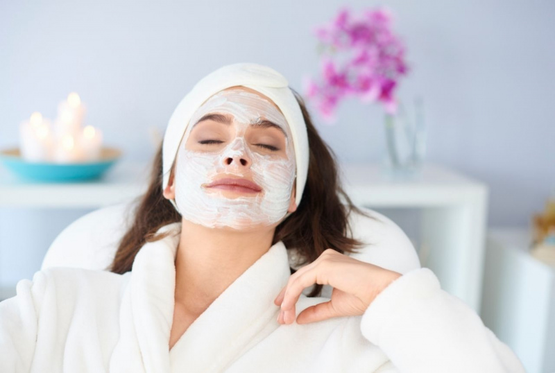 donna in relax maschera di bellezza applicata sul viso turbante accappatoio spugna bianco