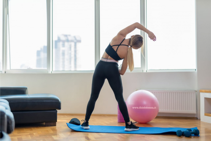 esercizi fisici a casa soggiorno donna stretching abbigliamento fitness palla rosa
