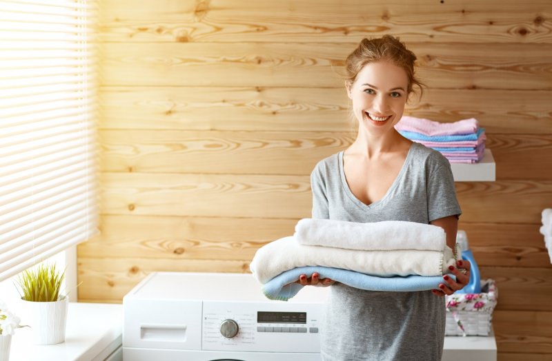bella donna sorridente felice del suo bucato in lavatrice