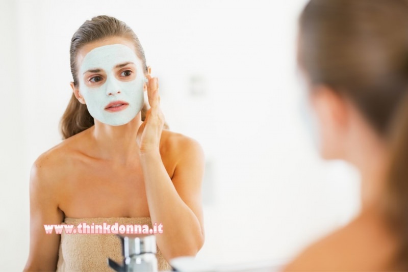 viso donna applica maschera di bellezza bagno telo spugna specchio