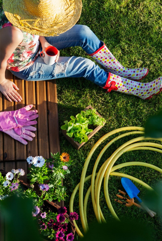 giovane donna jeans cappello di paglia sotto il sole relax riposo giardinaggio tubo acqua tazzina caff stivali giardino