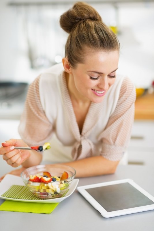 donna sorridente mangia cibo sano frutta 